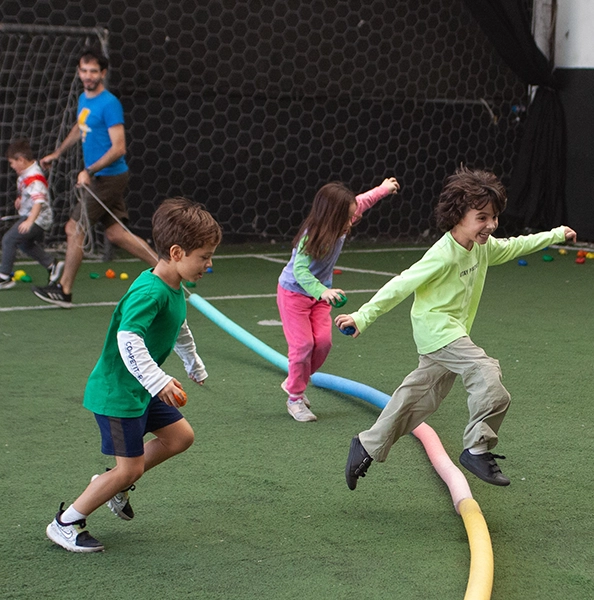 alumnos motrinfan jugando y corriendo saltando una víbora de juguete