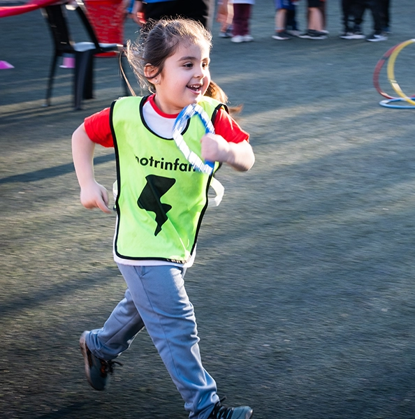 alumna motrinfan corriendo mientras profe motrinfan intenta atraparla con un aro