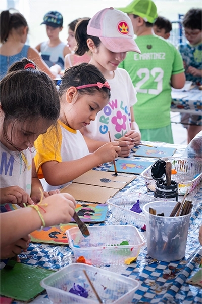 alumnos motrinfan pintando sobre una mesa